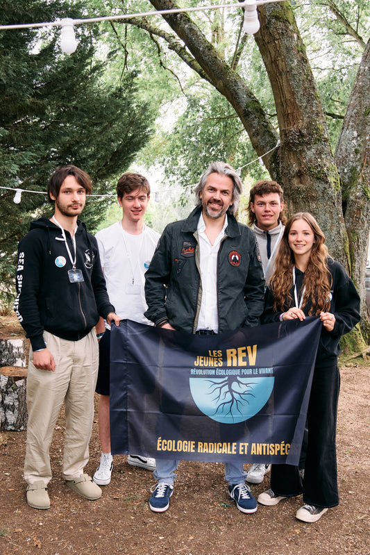 Drapeau Les Jeunes REV porté par nos référent.e.s avec Aymeric Caron